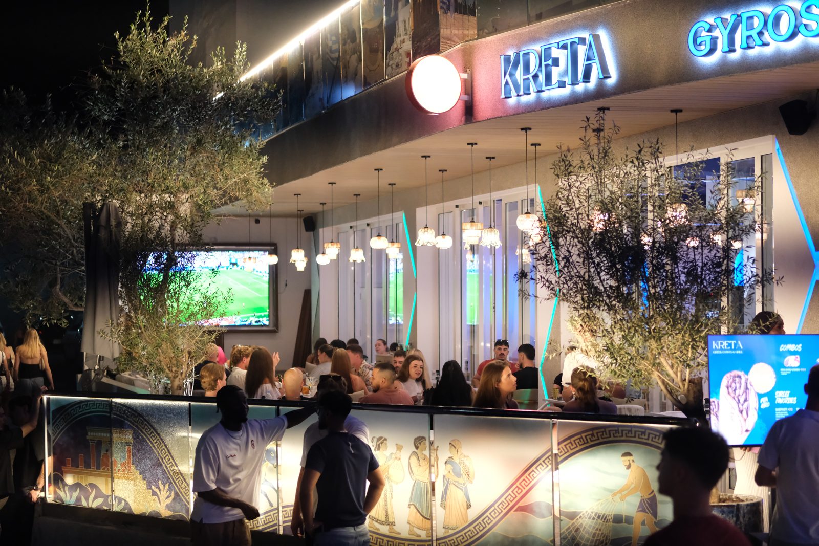Kreta Greek Gyros and Grill exterior at night in Paceville Malta with neon KRETA sign and packed terrace