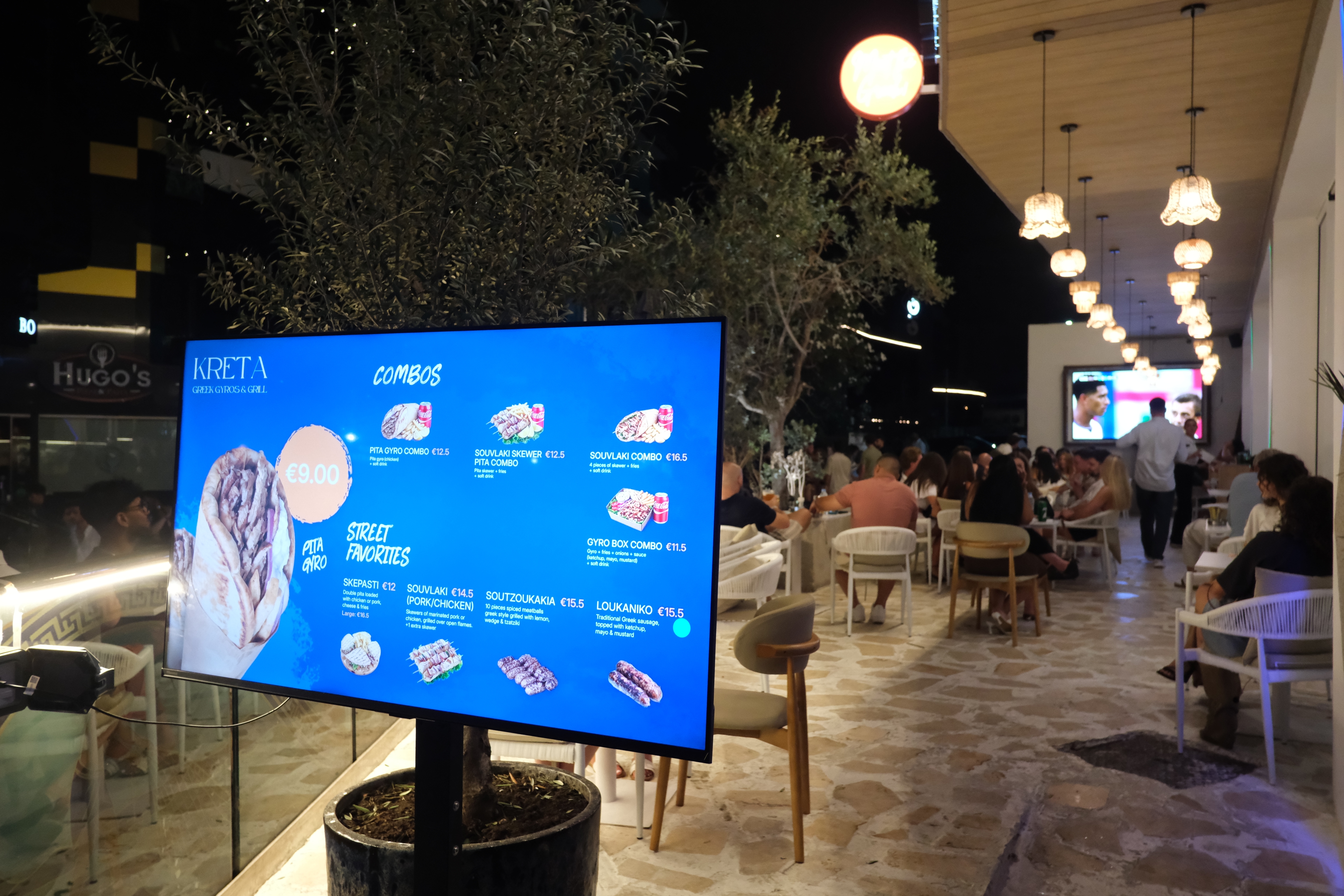 Kreta Greek Gyros and Grill menu board in Paceville Malta showing pita gyro at 9 euro and combo prices with GYROS & GRILL neon sign